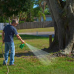 Homeowner,Man,Spraying,Weed,Killer,On,His,Front,Yard,With